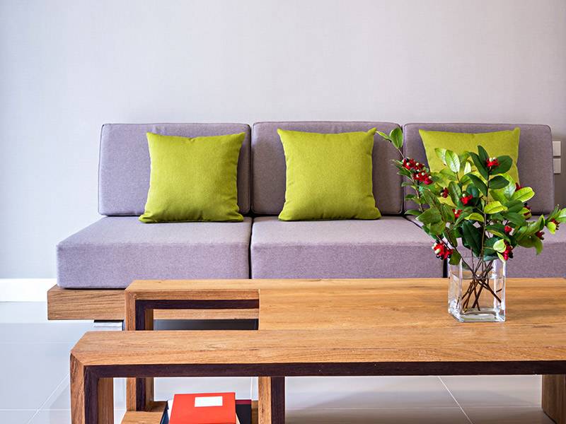 divano lilla con cuscini verdi