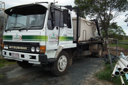 White Mitsubishi Truck with A Container, Parked on Gravel — Coastal Skip Bin Hire In Craignish, QLD