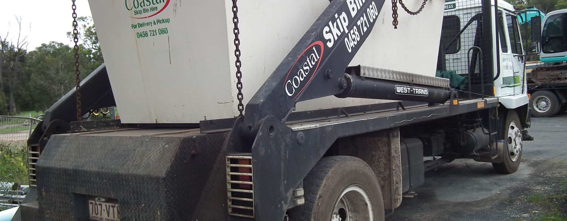 A White Skip Bin on A Flatbed Truck, Likely Used for Waste Removal — Coastal Skip Bin Hire In Craignish, QLD