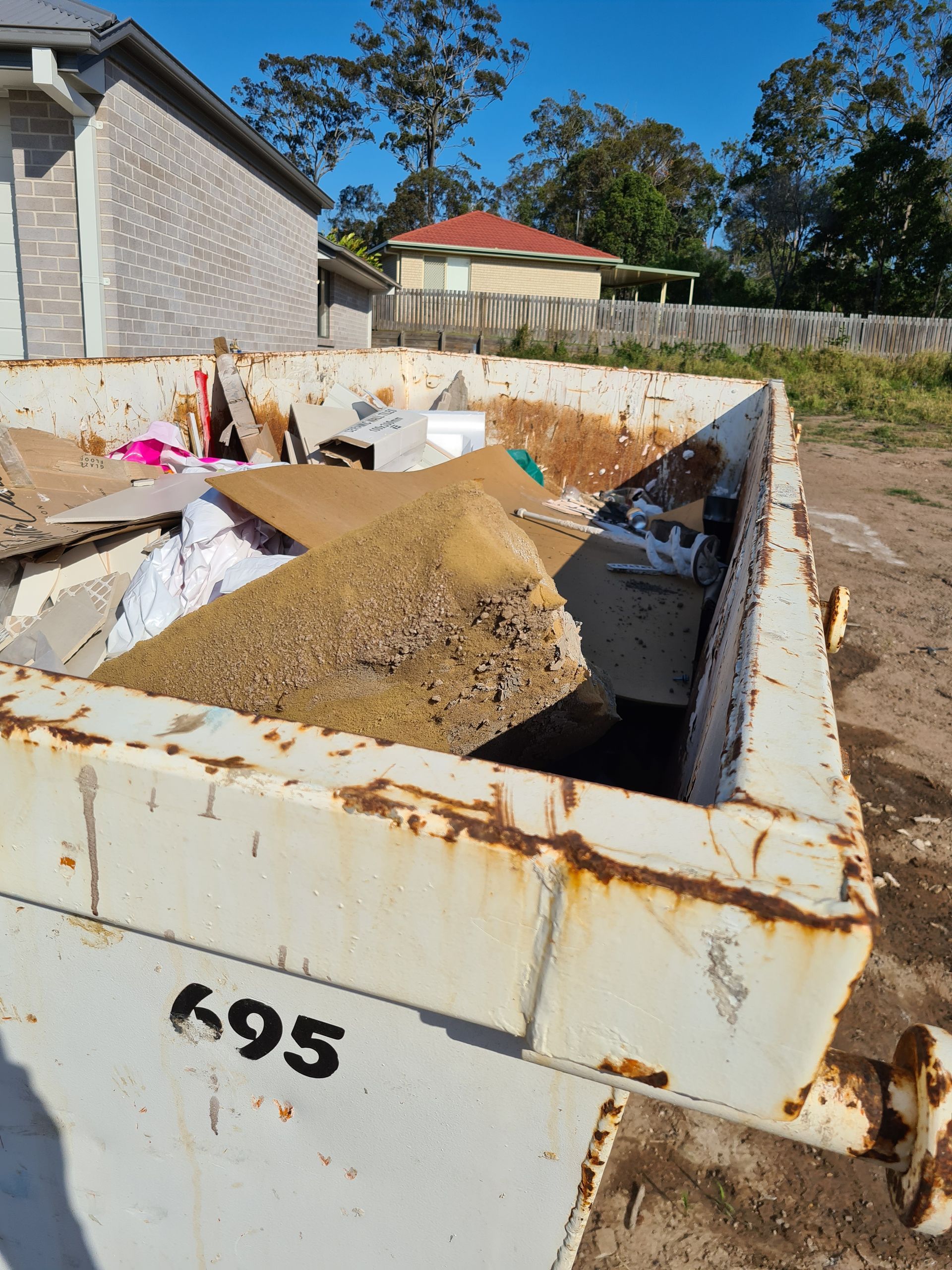 A rusty, overflowing dumpster labeled