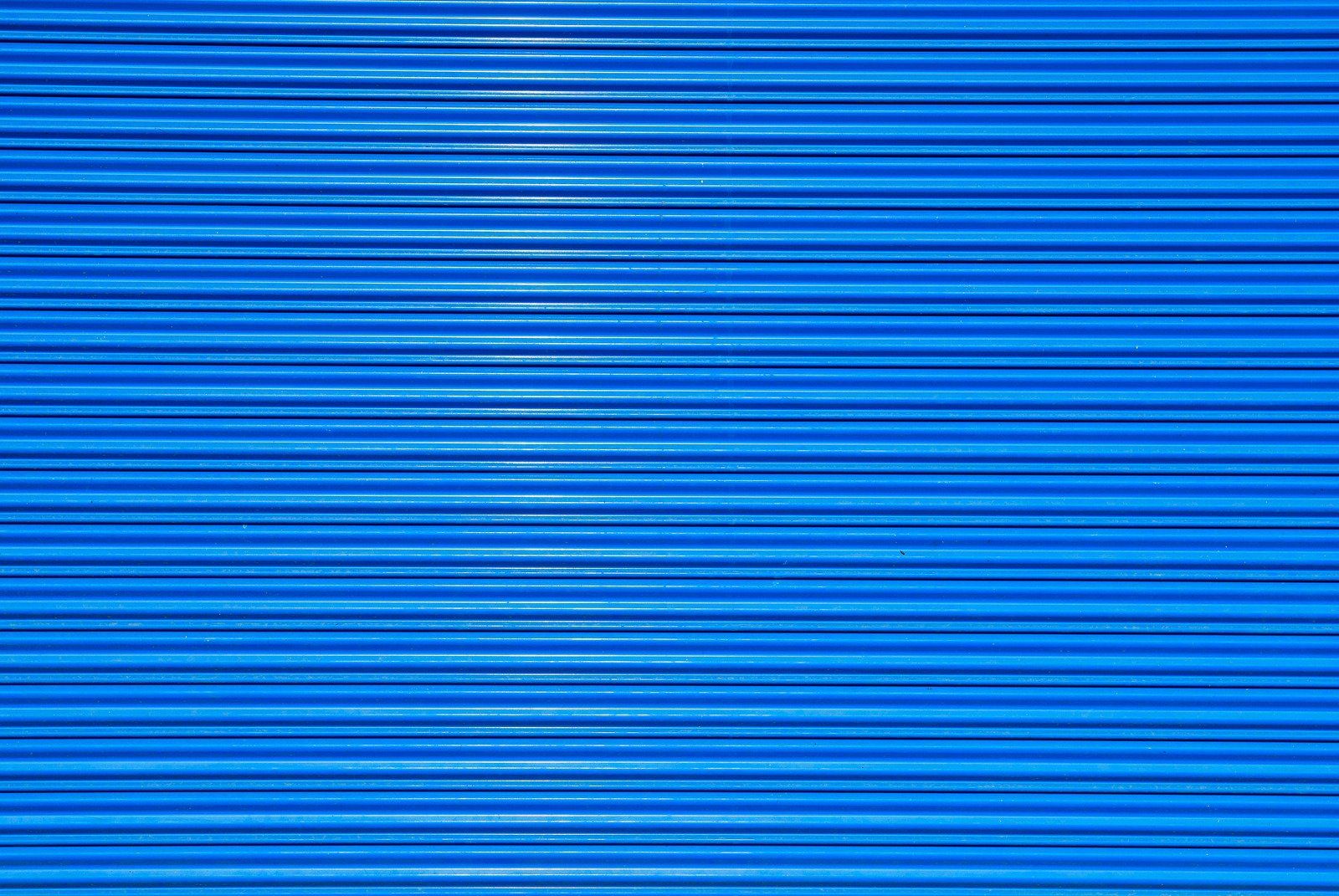 A close up of a blue metal shutter on a building.