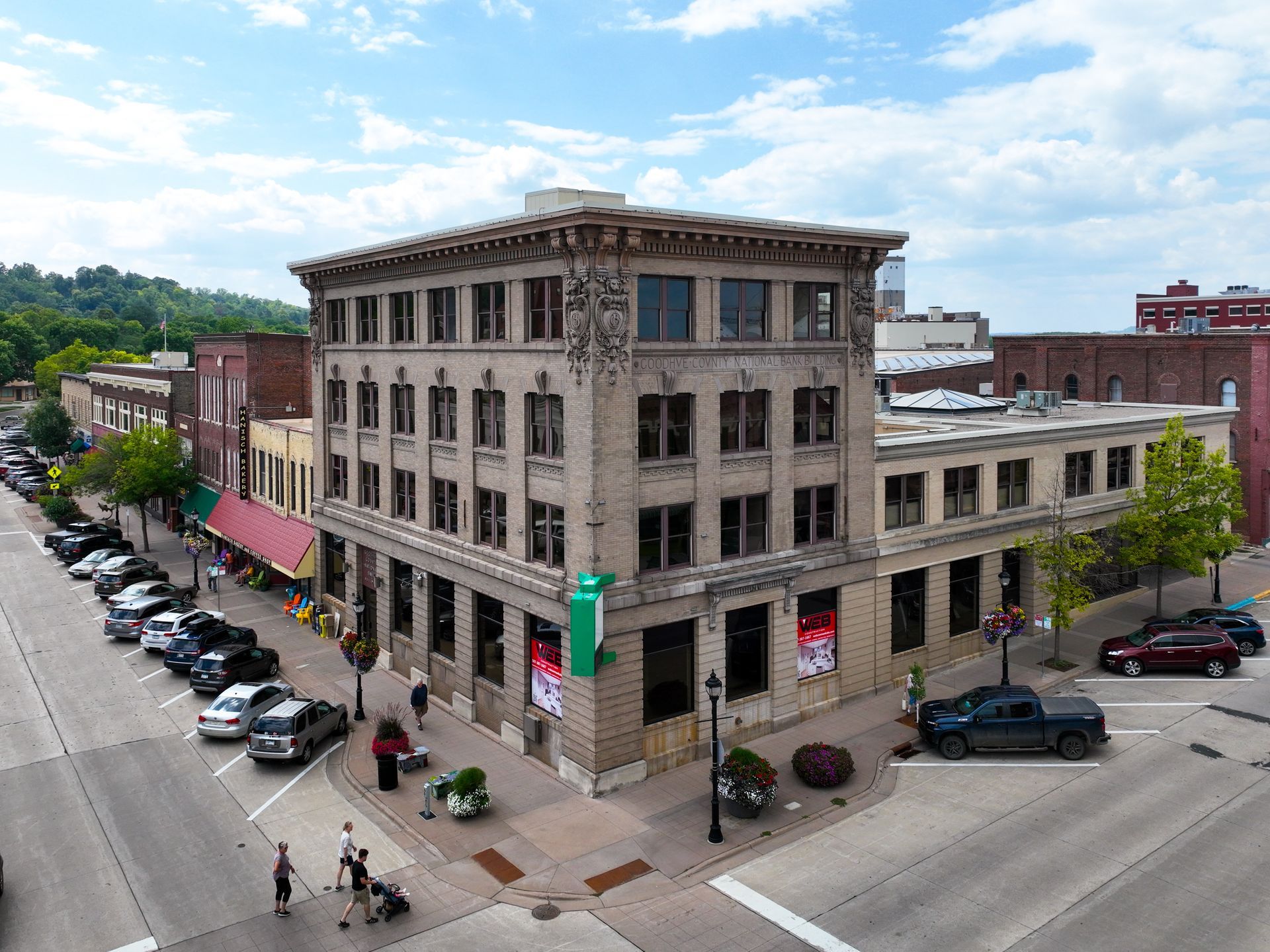 An aerial view of a large building on the corner of a city street.