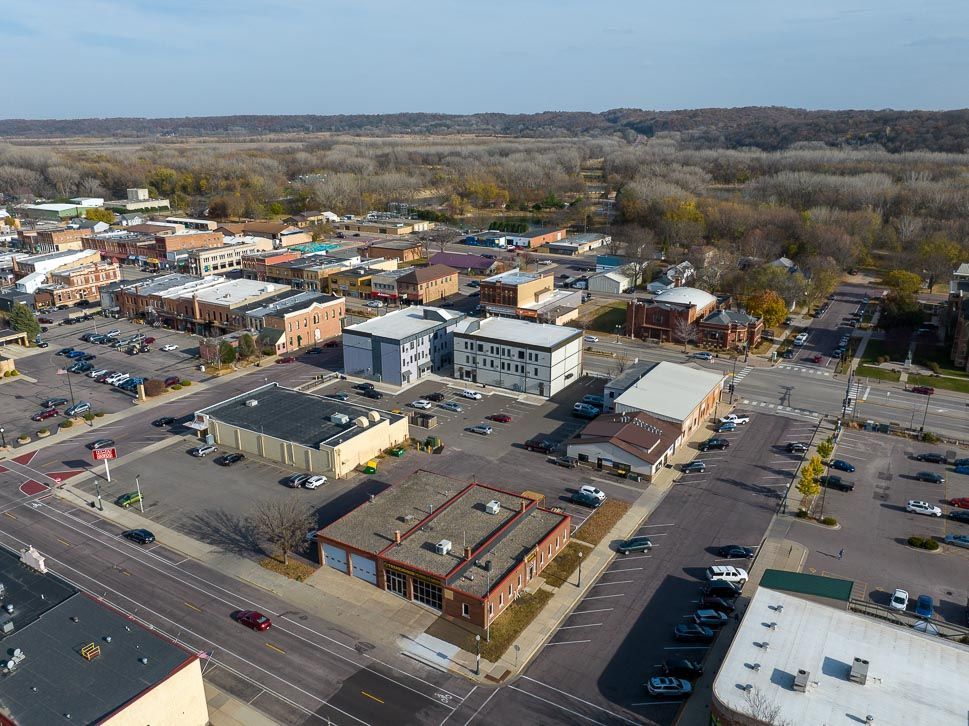 An aerial view of a small town with lots of buildings and parking lots.