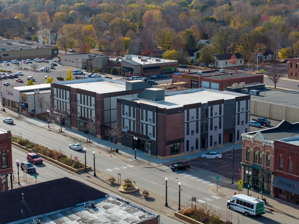 An aerial view of a city street with a large building in the middle of it.