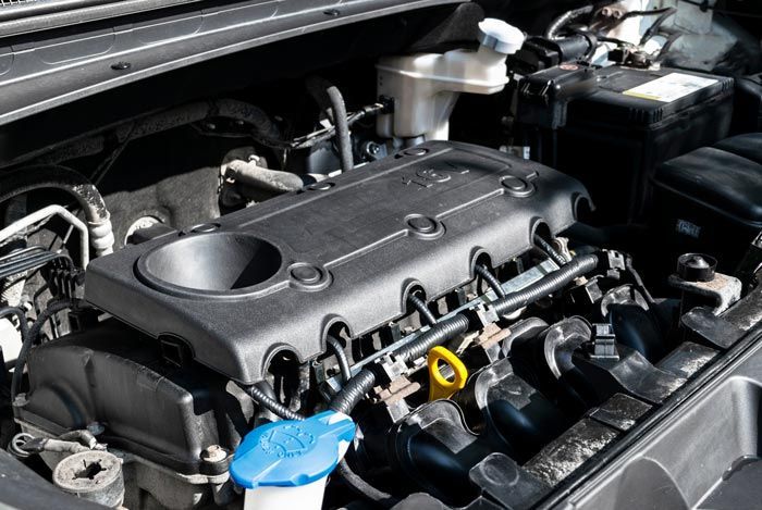 A close up of a car engine with the hood open.
