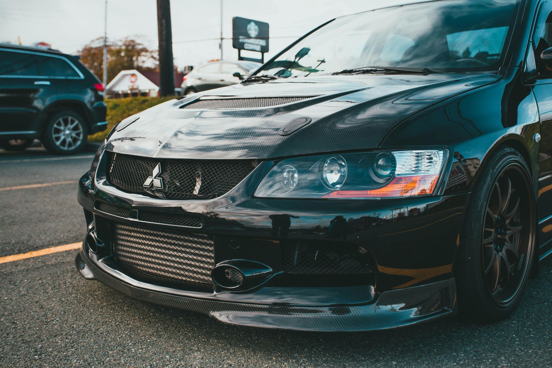 A black mitsubishi lancer evolution is parked in a parking lot.