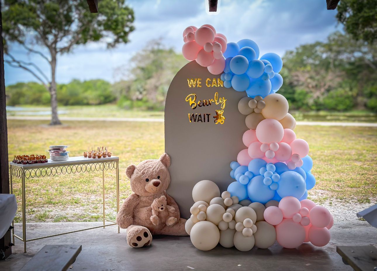 A bunch of pink, blue and white sand balloons are sitting on top of an arch wall.