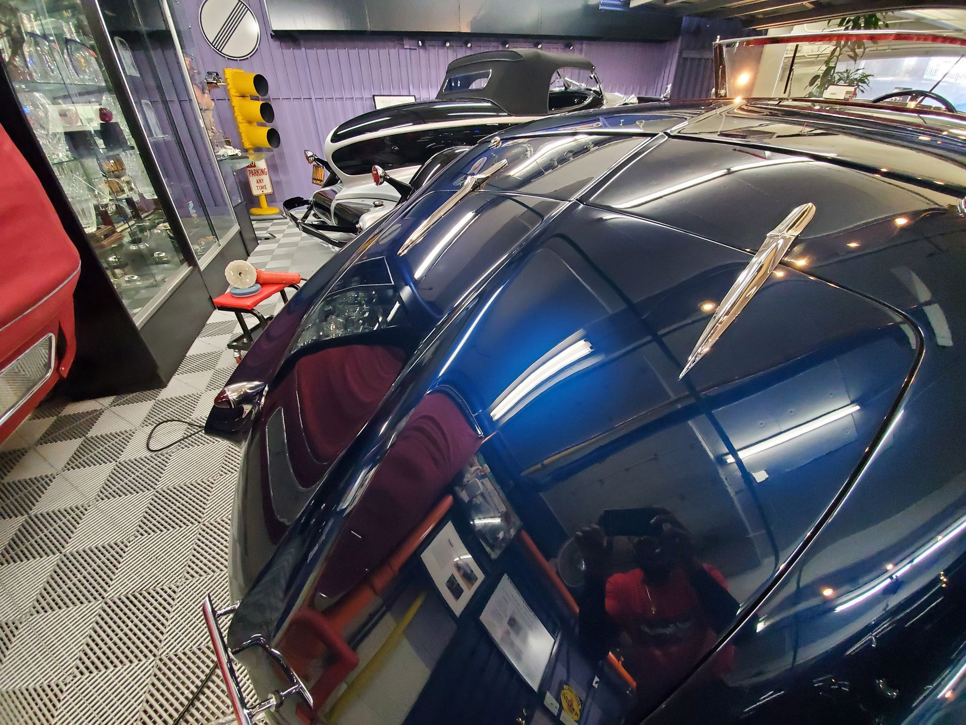Blue classic car hood with a chrome ornament, interior setting.