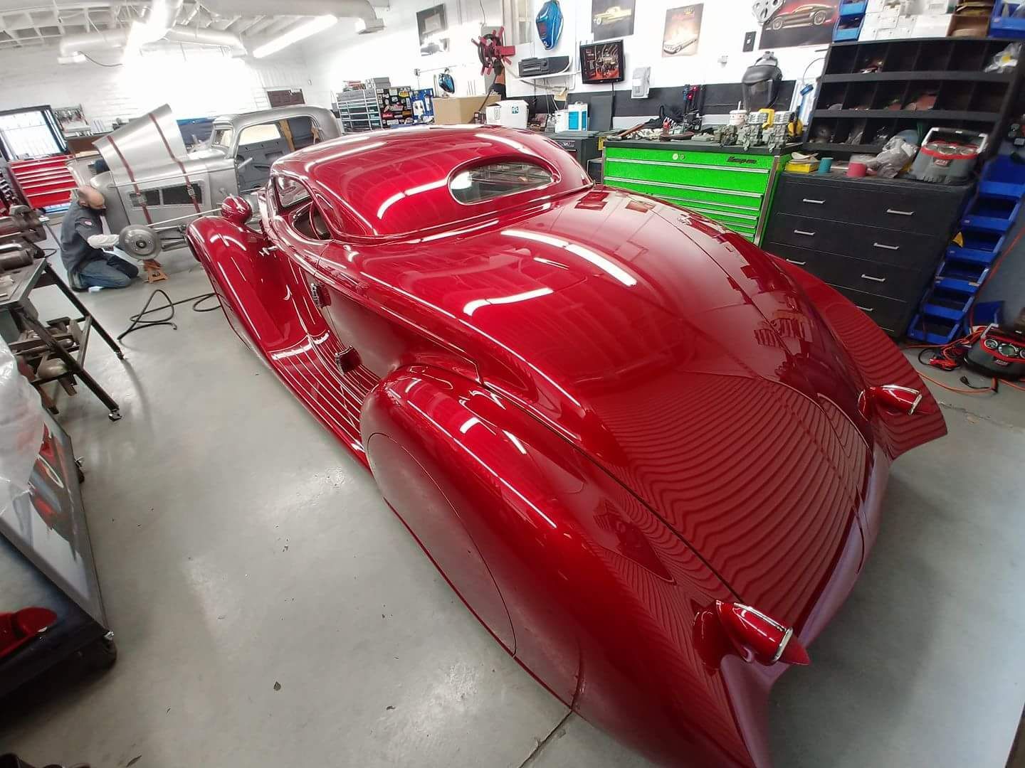 Red custom vintage car in a workshop.