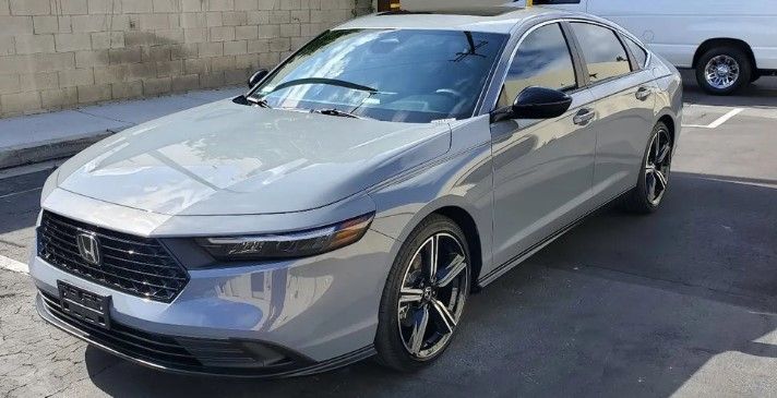 Gray Honda Accord sedan parked on asphalt, with black accents and a light background.
