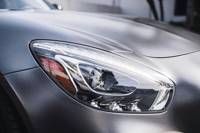 Silver sports car headlight and hood.