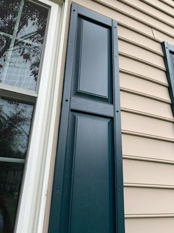 A close up of a window with blue shutters on a house.