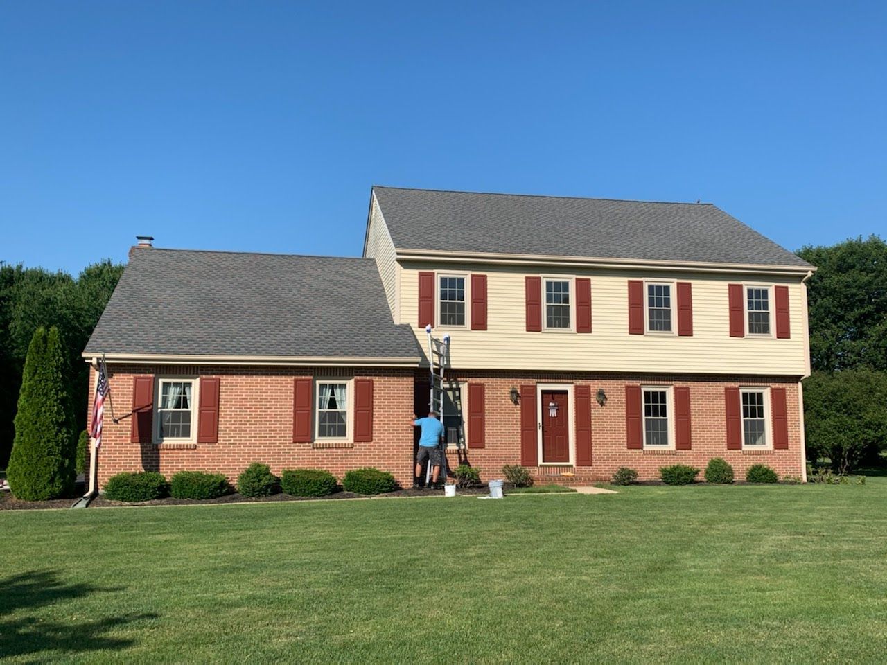 A large house with a lot of windows and red shutters