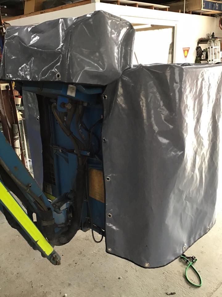 A Gray Tarp is Covering a Machine in a Warehouse — Isa Auto Glass & Upholstery In Menzies, QLD