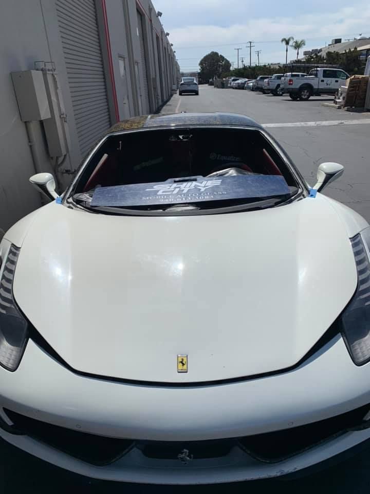 A white ferrari sports car is parked in a parking lot