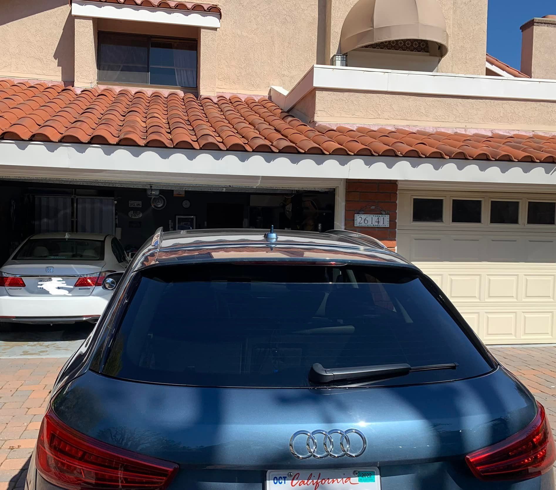 A blue audi is parked in front of a house