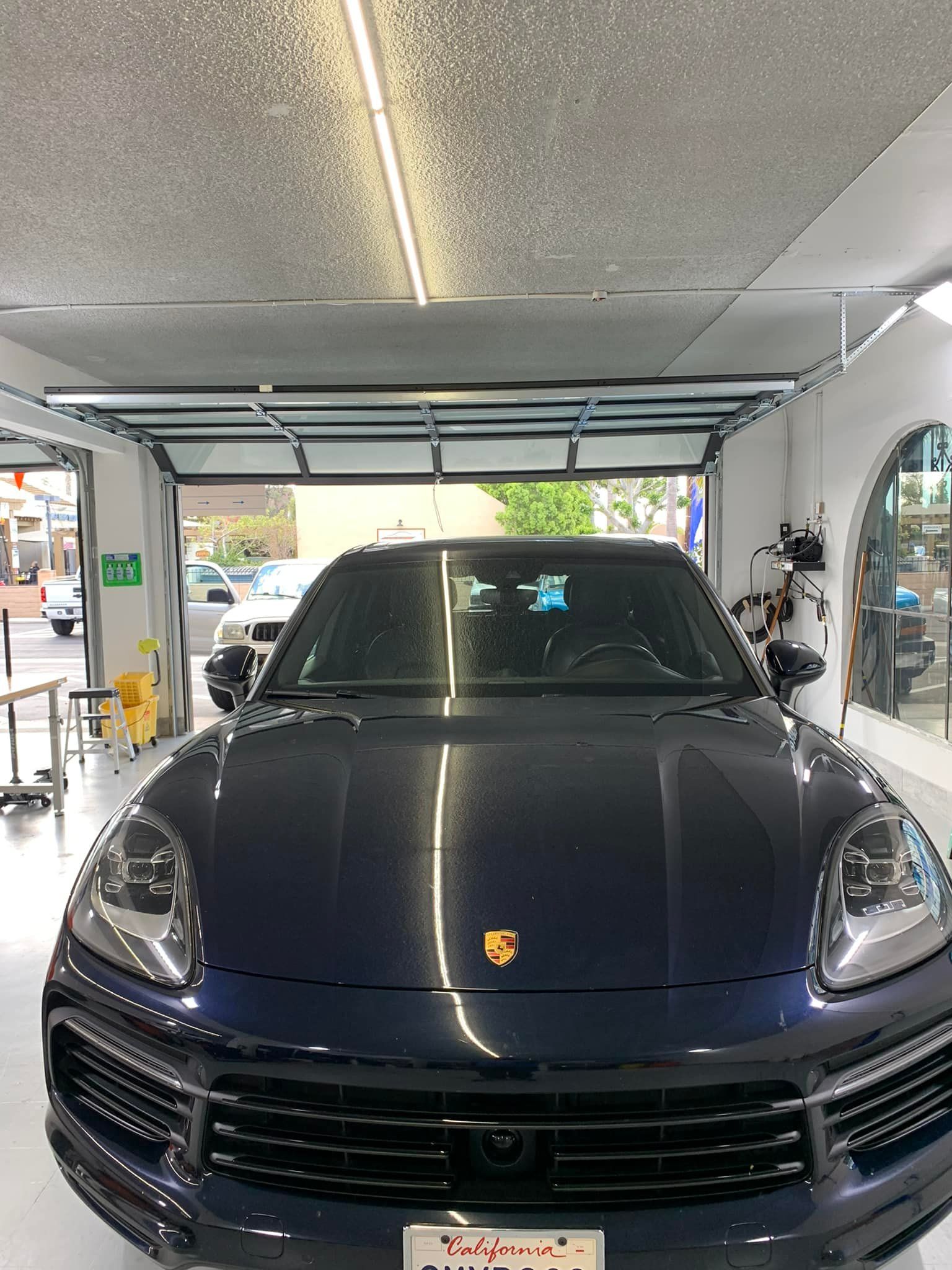 A black porsche cayenne is parked in a garage.