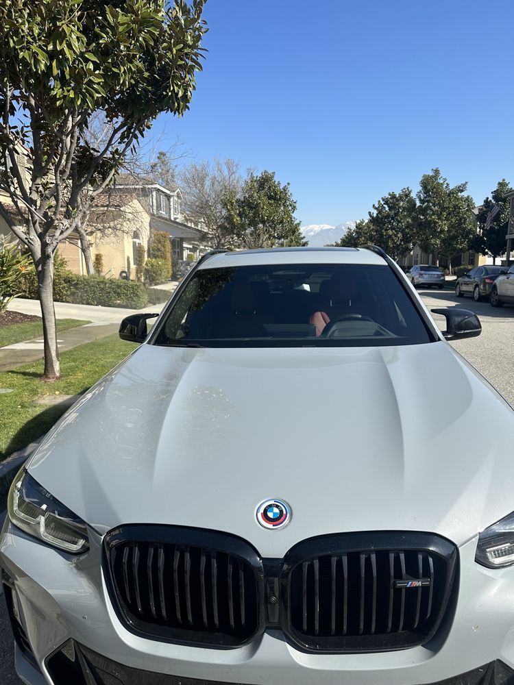 A white bmw x3 is parked on the side of the road.
