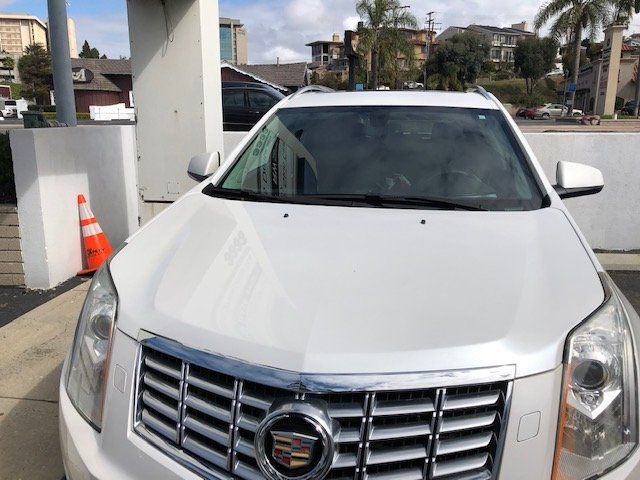 A white cadillac is parked in a parking lot.