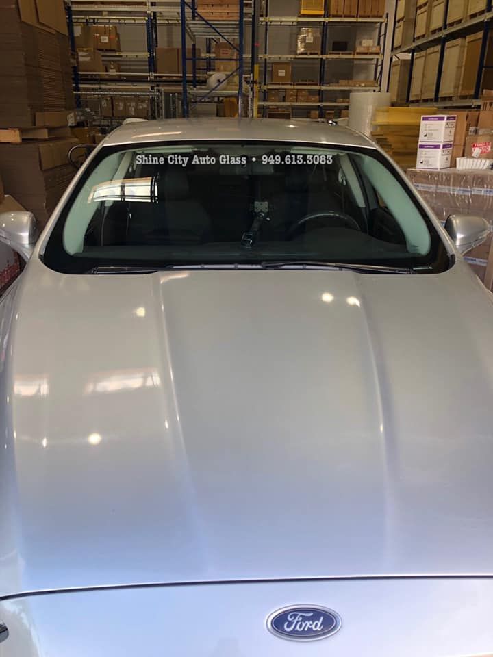 A silver ford fusion is parked in a warehouse.