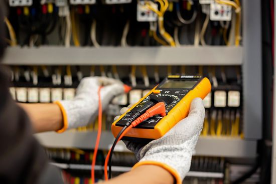 a person is holding a digital multimeter in their hands .