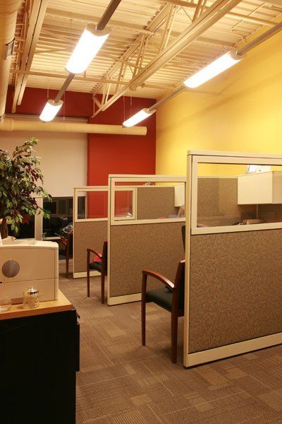 A row of cubicles with chairs in an office