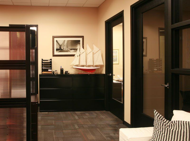 A model sailboat sits on a dresser in a hallway