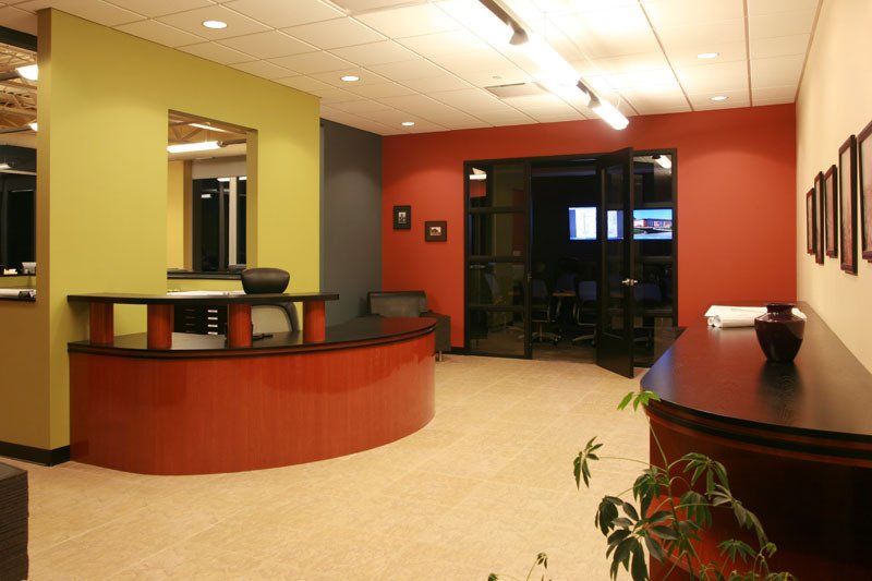 A reception area with a curved counter and red walls