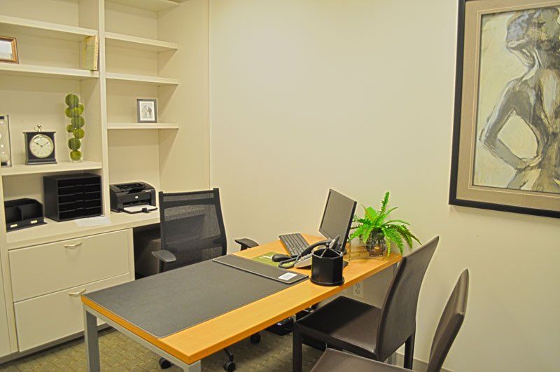 A small office with a desk , chairs and a computer.