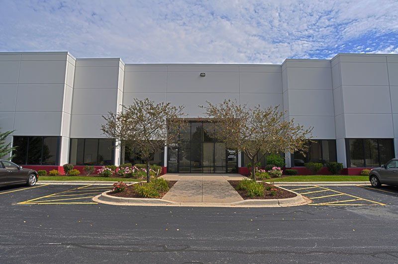 A large white building with cars parked in front of it