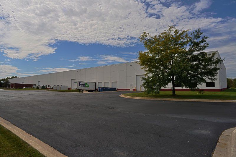 A large white building with a truck parked in front of it.