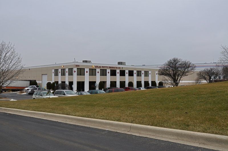 A large building with a lot of cars parked in front of it
