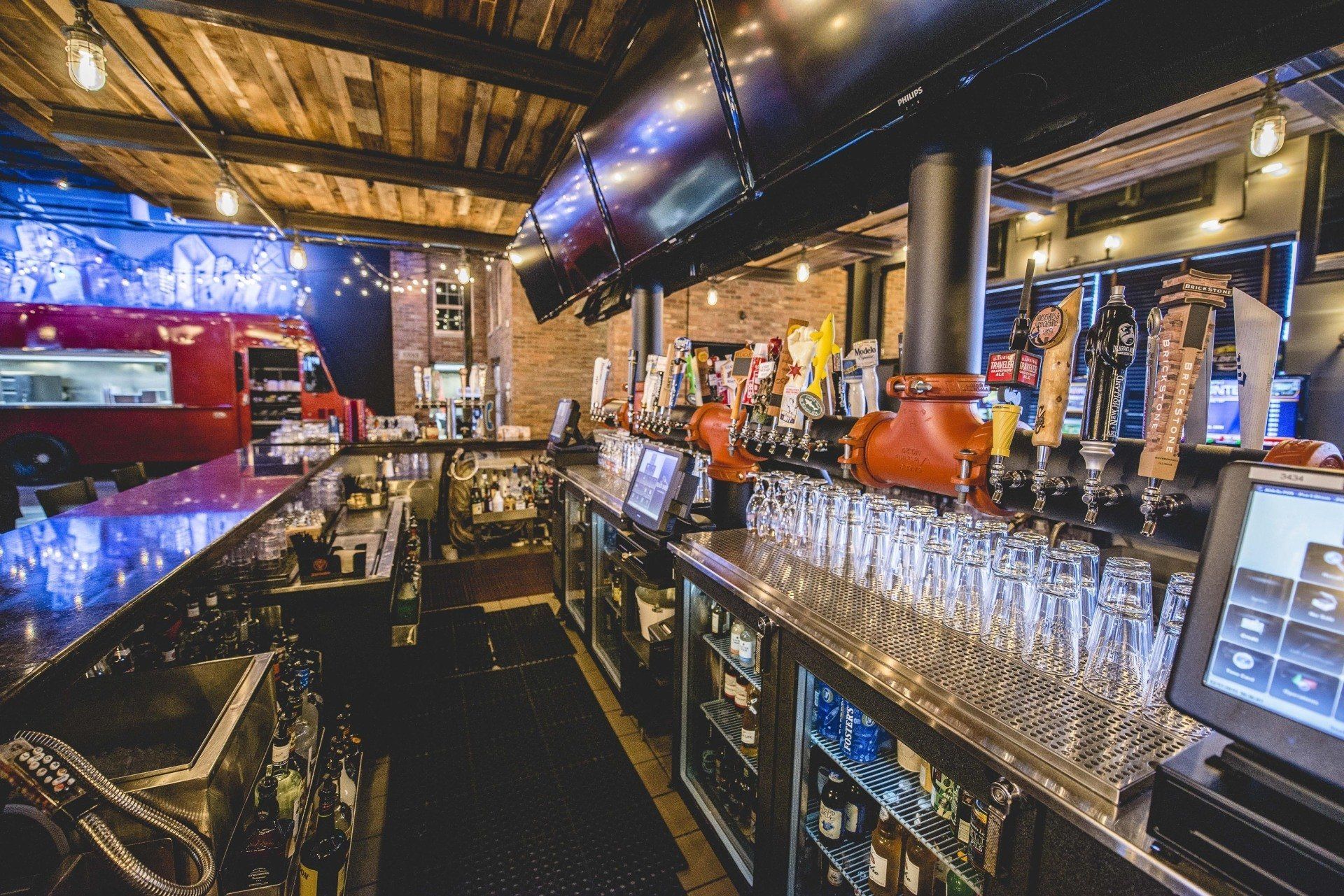 A long bar in a restaurant with a lot of glasses on it.