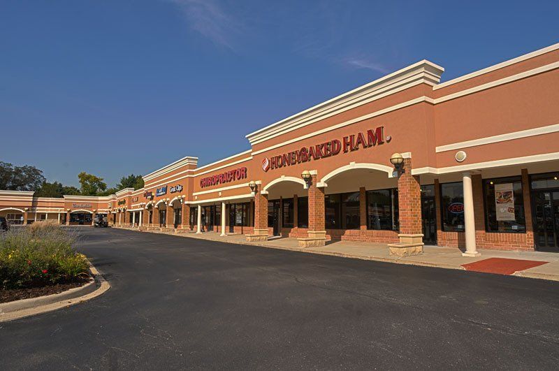 A row of stores are lined up in a shopping center.