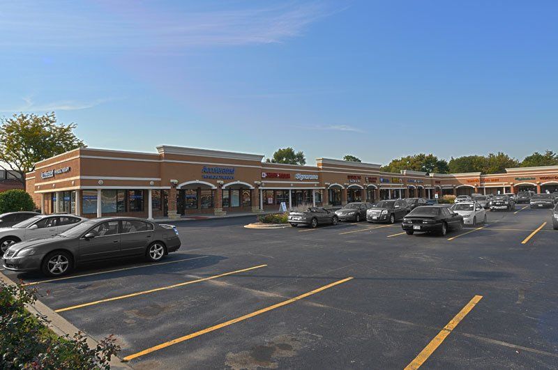 A parking lot with cars parked in front of a building.