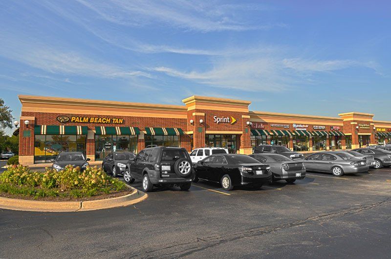 A lot of cars are parked in front of a building that says sprint