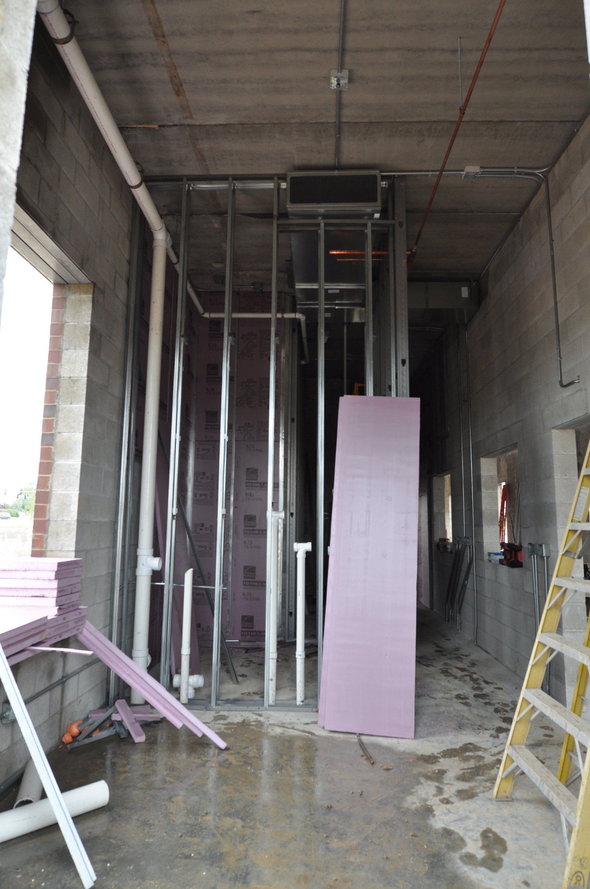 A building under construction with a ladder in the foreground