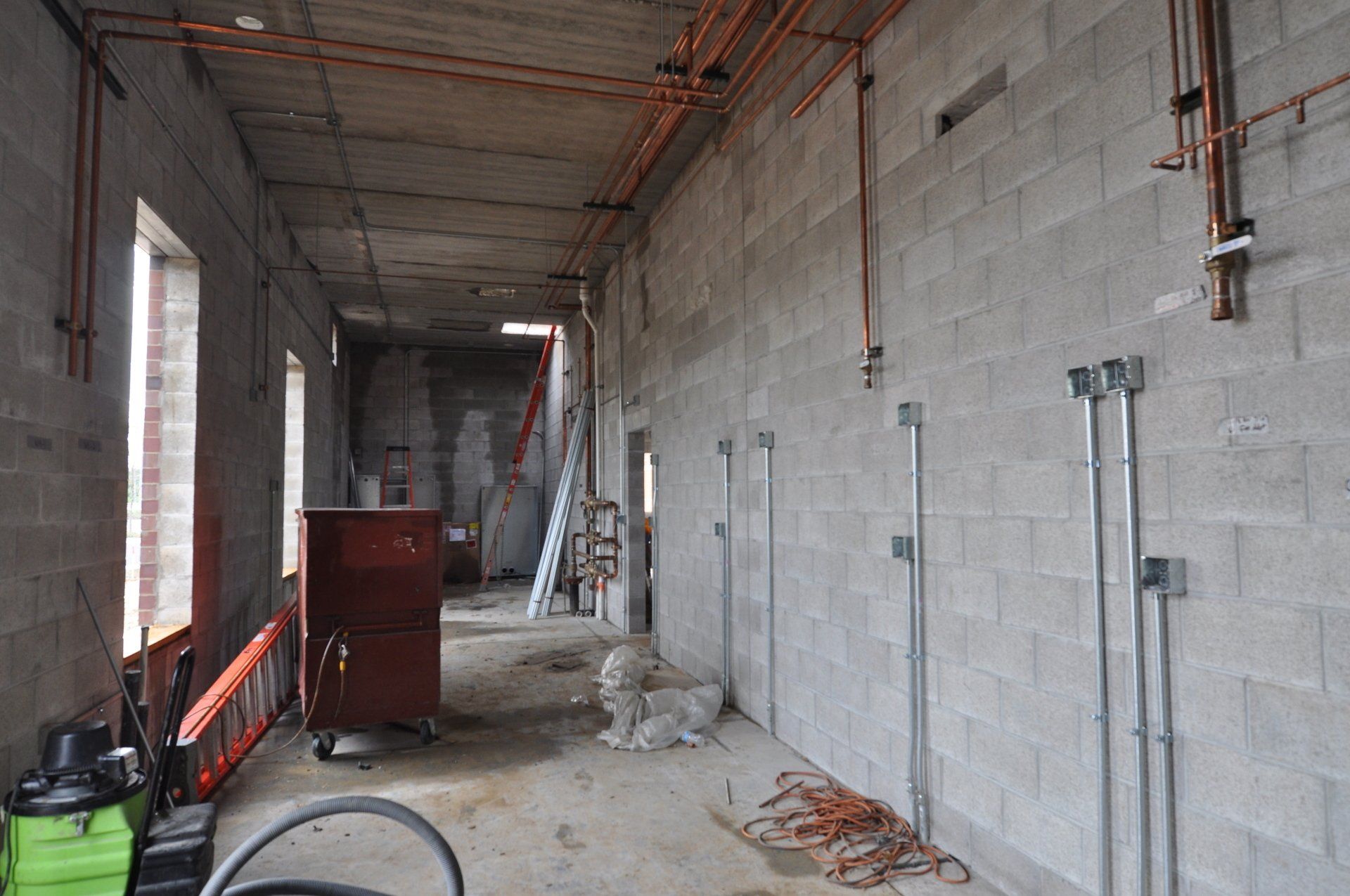 A room with brick walls and pipes hanging from the ceiling