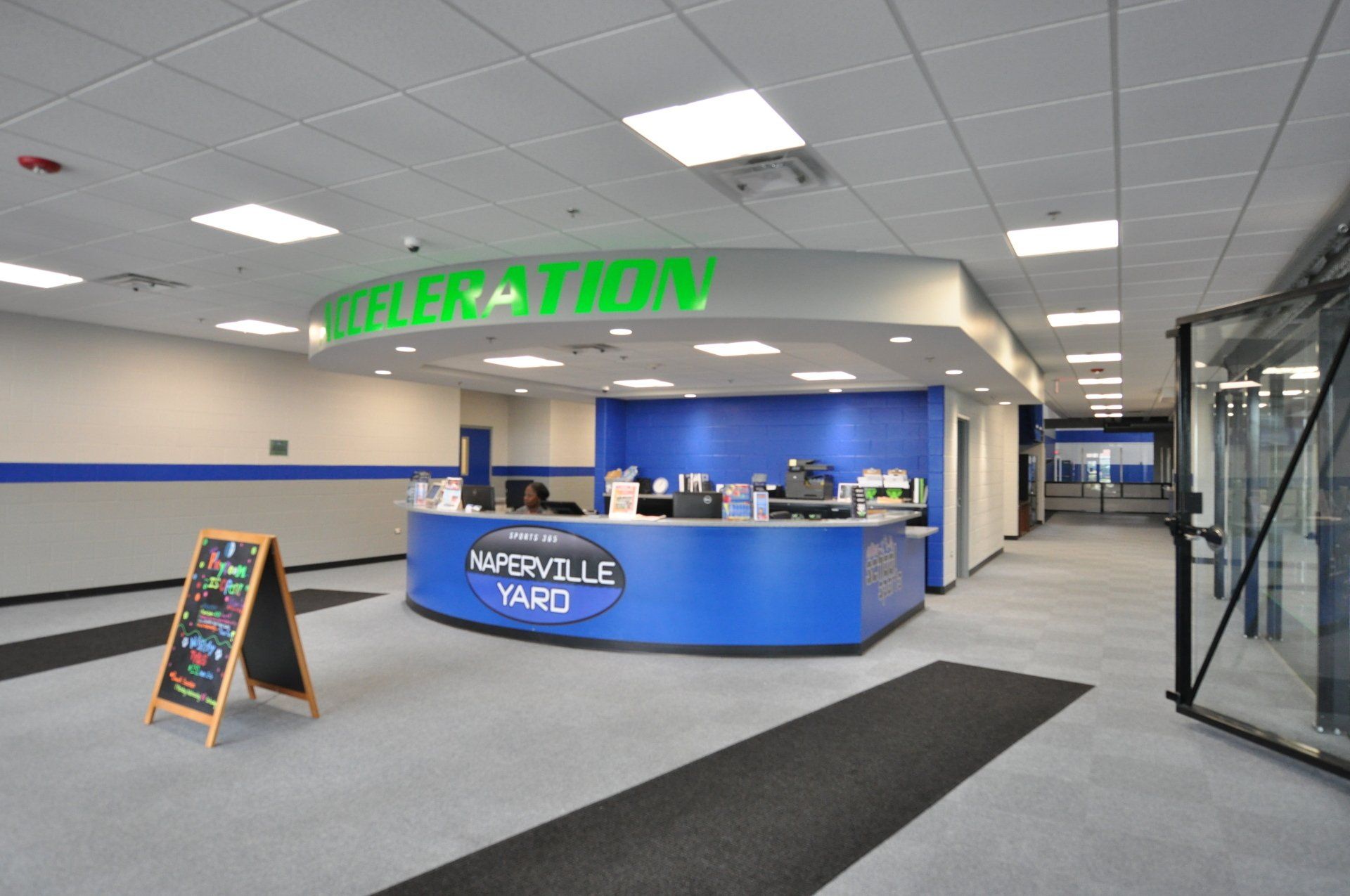 A lobby with a blue counter and a sign that says acceleration
