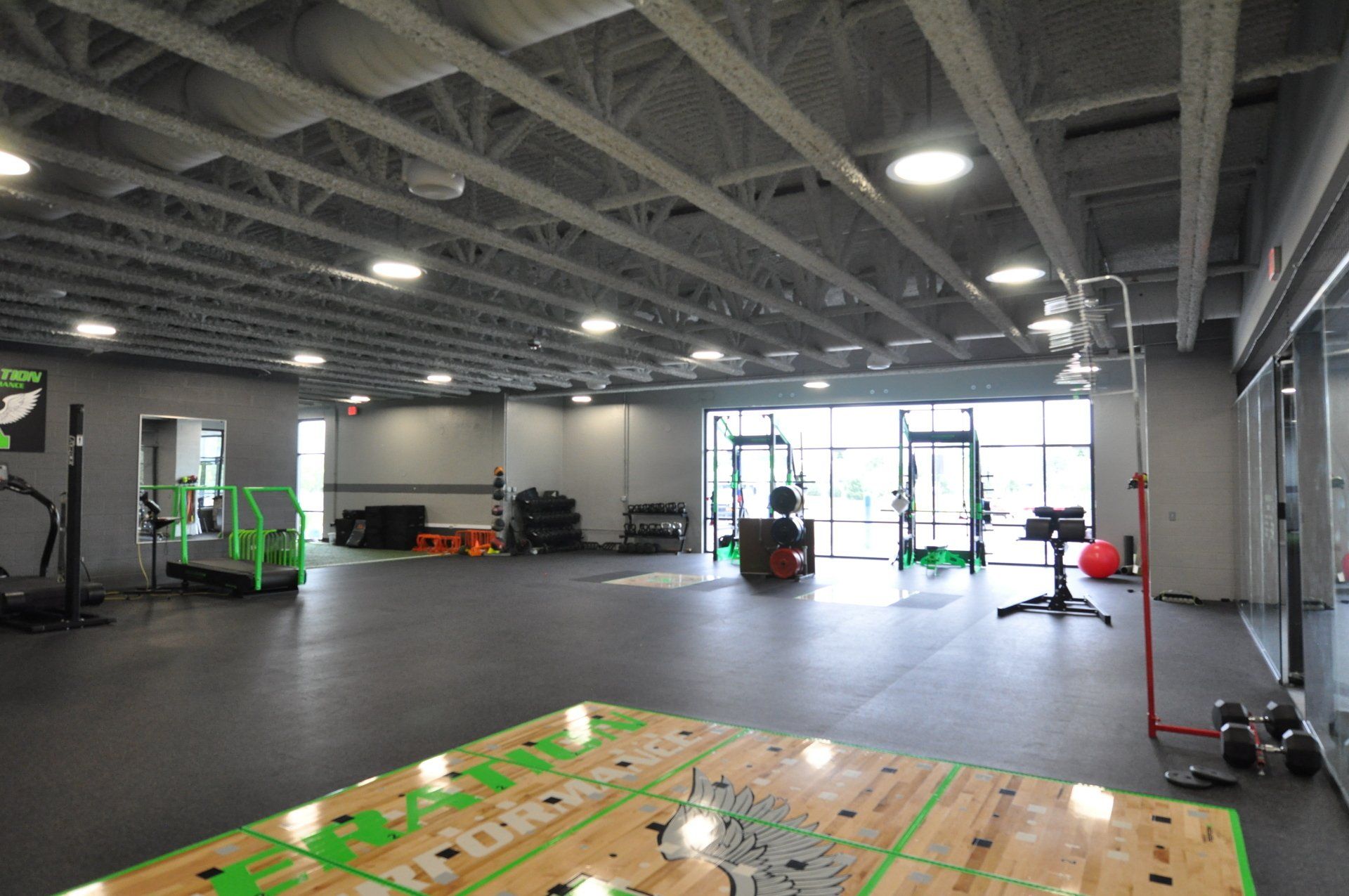 A large gym with a wooden floor and a basketball court.
