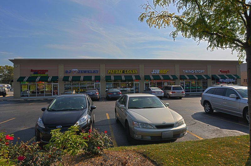 A parking lot with cars parked in front of a building.
