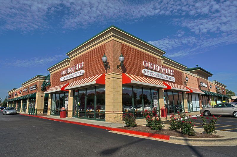 A large brick building with a red awning on the side of it.