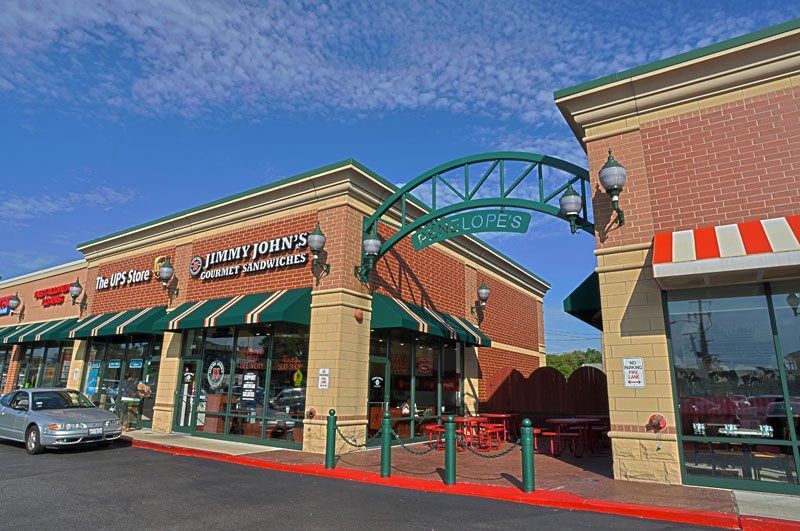 A car is parked in front of a store called lighthouse