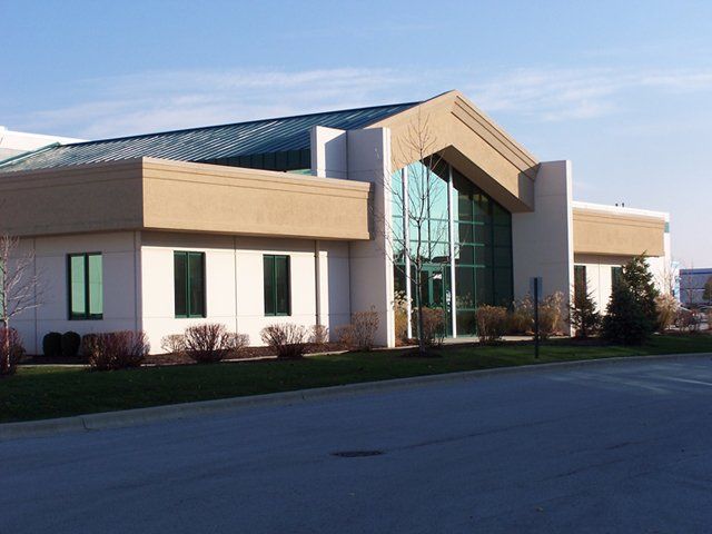 A white building with a green roof and a lot of windows