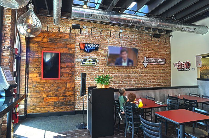 A restaurant with tables and chairs and a brick wall