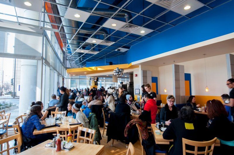 A group of people are sitting at tables in a restaurant.