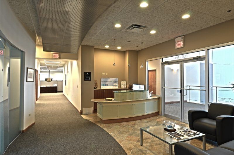 A lobby with a reception desk , chairs and a coffee table