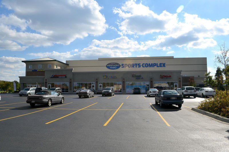 Cars are parked in front of a sports complex