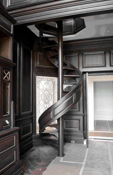 A wooden spiral staircase in a dark room
