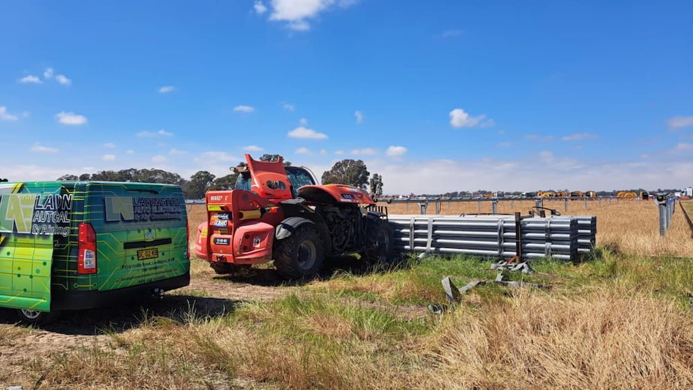 A Green Van is Parked Next to a Red Tractor in a Field — Lavington Auto Electrical in Lavington, NSW